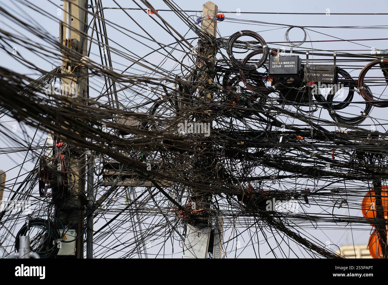 On voit des câbles de communication et de transmission d'énergie attachés à un poteau de rue dans le centre de Bangkok, en Thaïlande. Banque D'Images