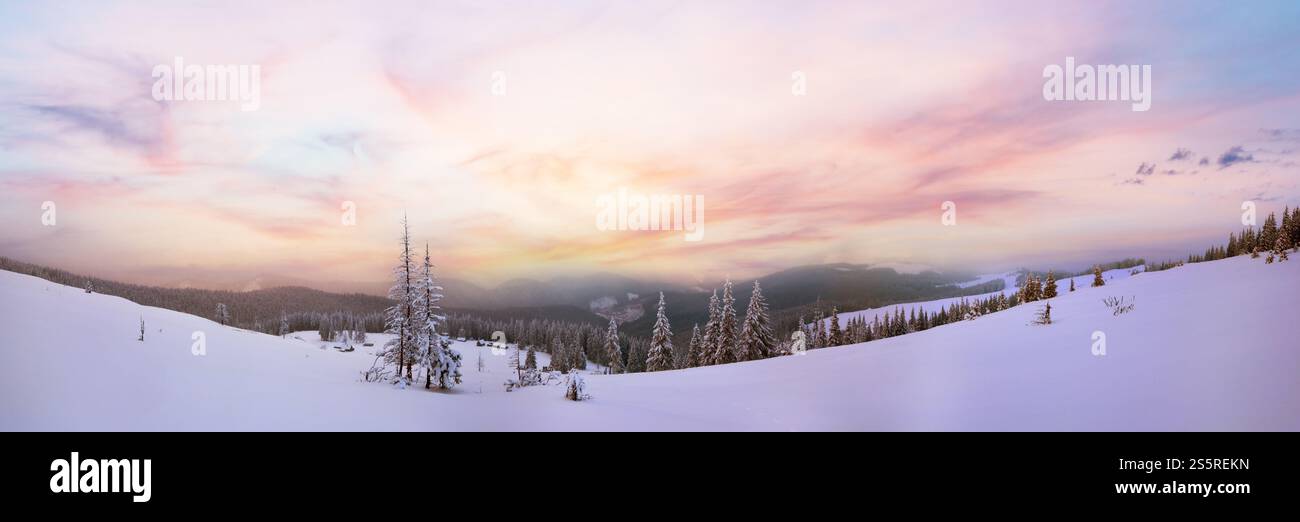 Crépuscule du soir calme d'hiver paysage de montagne avec des maisons en groupe et monter derrière la crête (Carpates, Ukraine). Banque D'Images