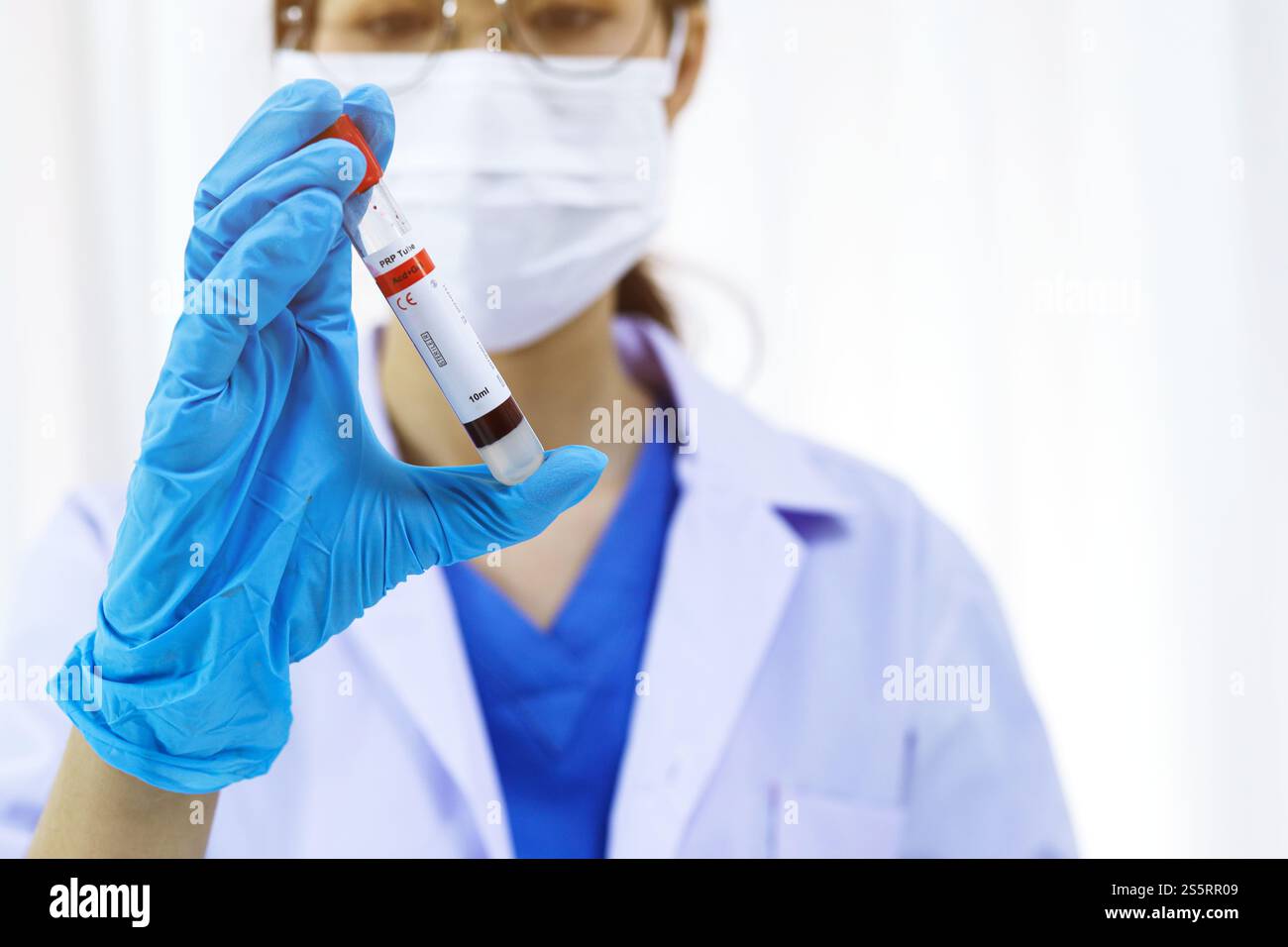 Scientifique tenant un tube de prélèvement sanguin infecté par le coronavirus covid-19. Analyse ADN du sang en laboratoire avec des tubes de prélèvement de sang et Banque D'Images