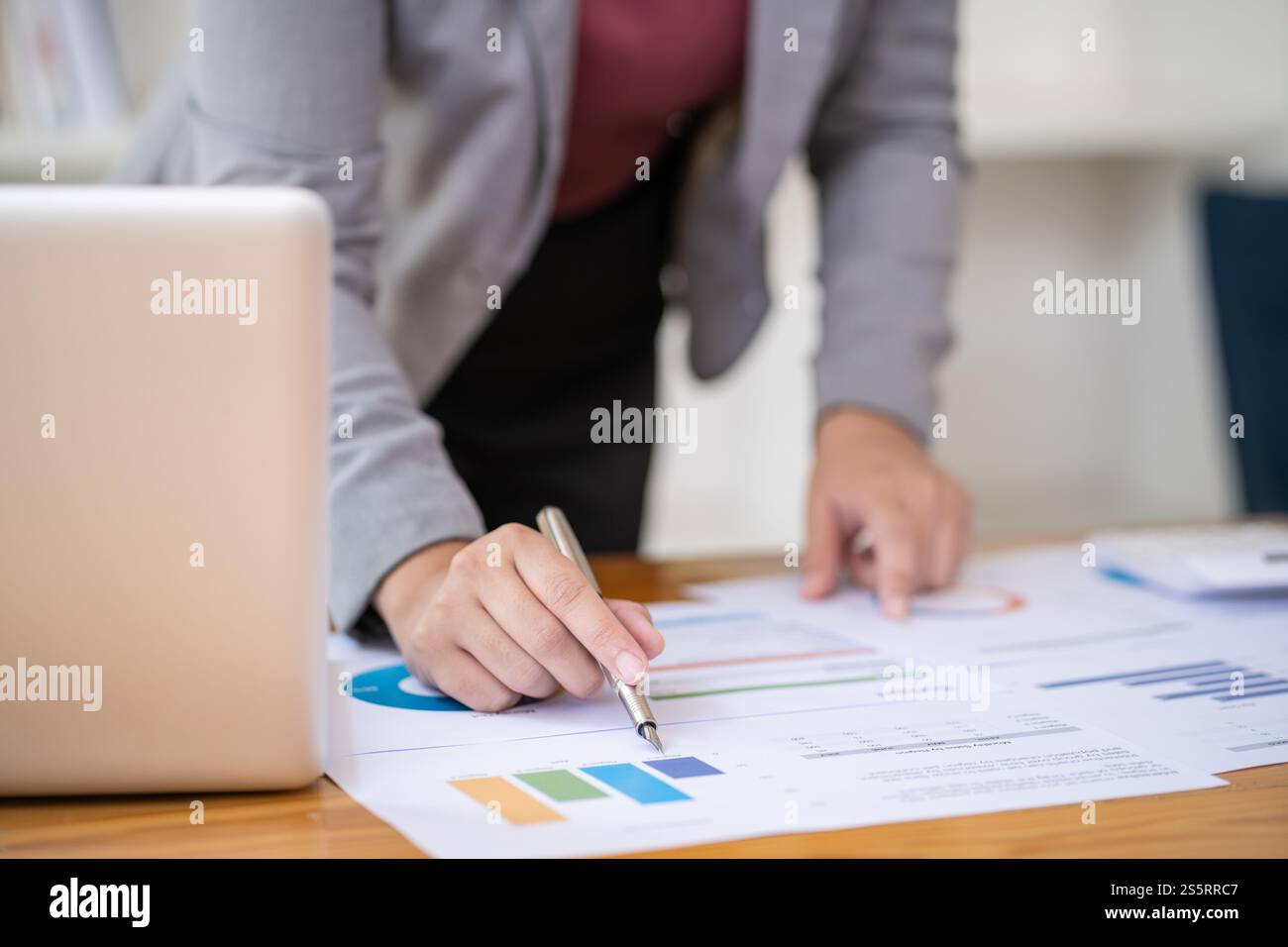 Femme d'affaires comptable analysant les graphiques d'investissement facture et appuyant sur les boutons de calculatrice sur les documents. Commis comptable Conseiller de banque Banque D'Images