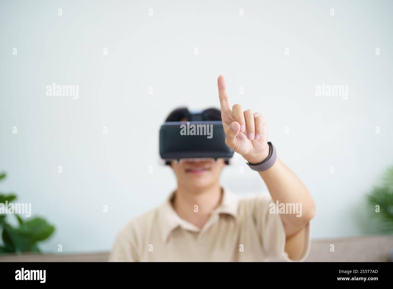 Jeune joueur d'homme asiatique portant la réalité virtuelle touchant l'air pendant l'expérience VR future Home Technology Player hobby concept de plaisir ludique Banque D'Images