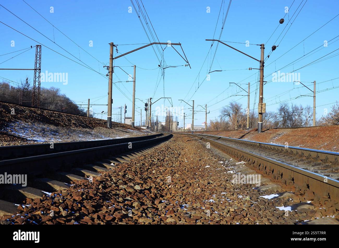 Paysage d'un chemin de fer d'hiver russe enneigé sous la lumière du soleil les rails et les traverses sous la neige de décembre. Chemins de fer russes en détail. Hiver Banque D'Images