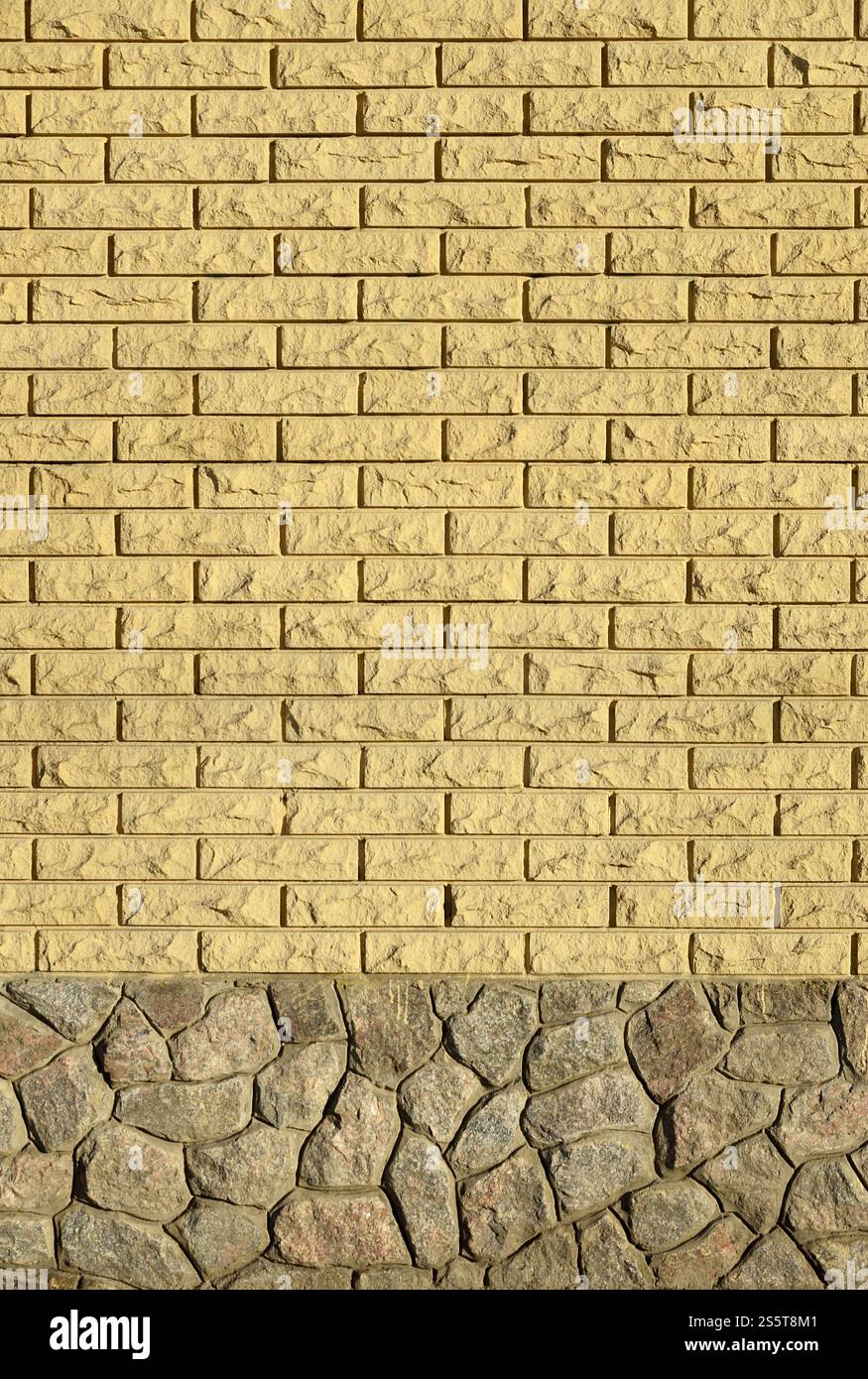 La texture des murs de la brique en pierre moderne de haute qualité. Mur de briques de texture lisse avec des fondations en pierre faites à la main en plein soleil dans le Banque D'Images