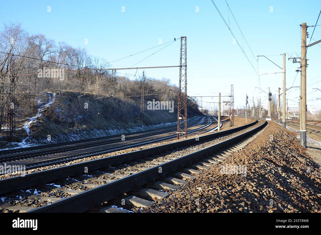 Paysage d'un chemin de fer d'hiver russe enneigé sous la lumière du soleil les rails et les traverses sous la neige de décembre. Chemins de fer russes en détail. Hiver Banque D'Images