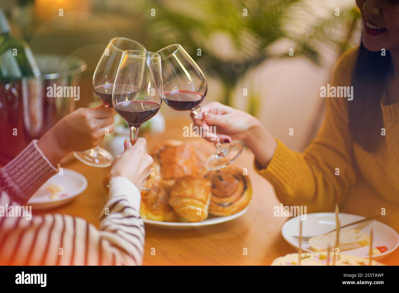 Amis joyeux appréciant la fête de vacances d'anniversaire à la maison. Amis asiatiques acclamant boire du vin rouge célébrant la fête du nouvel an Banque D'Images