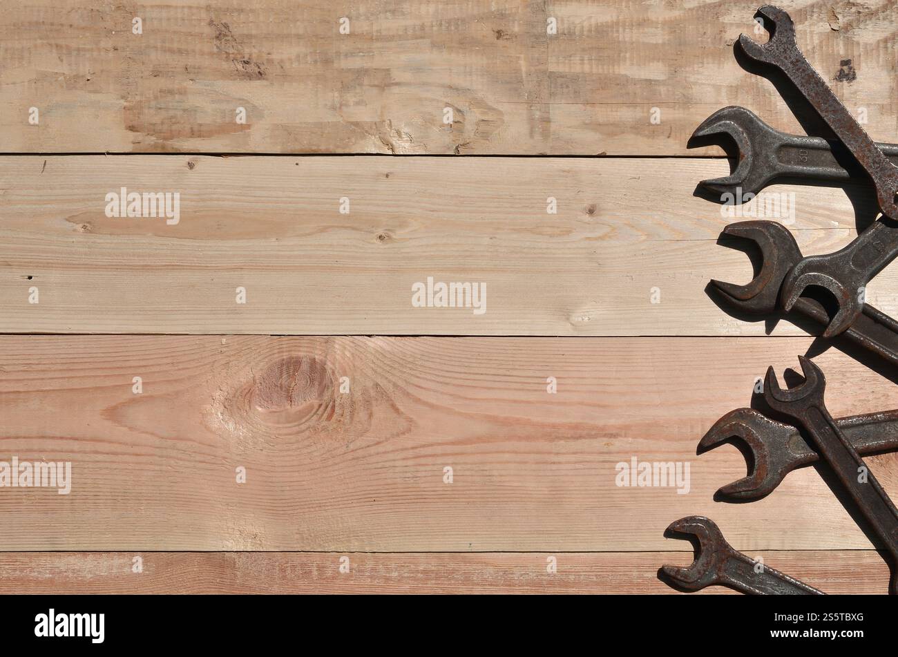 Quelques clés rouillées sur un fond en bois. Des outils ménagers obsolètes en métal rouillé reposent sur une table en bois dans un atelier. Le concept de réparation Banque D'Images