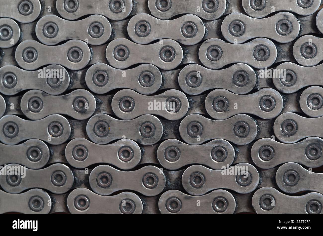 Chaîne sale et huileuse d'un vélo de montagne couché sur une table en bois dans un magasin de vélos. Un des principaux éléments de la transmission du couple sur les vélos Banque D'Images