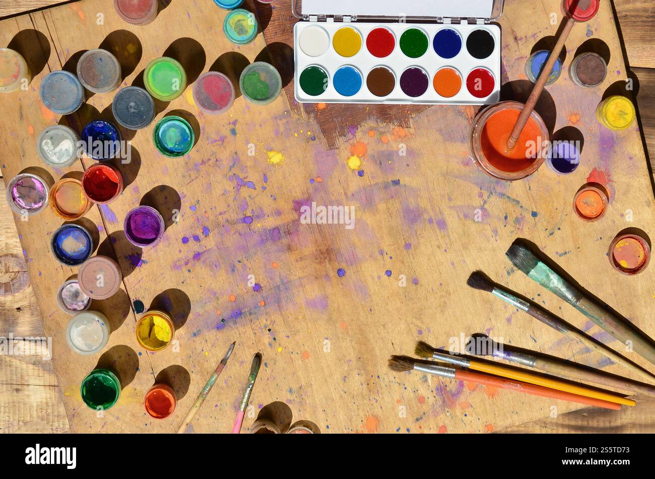 Nature morte, montrant un intérêt pour la peinture à l'aquarelle et choisi Beaucoup de pinceaux, de pots avec de la peinture à l'aquarelle et de gouache usagée reposent sur un vieux bois Banque D'Images