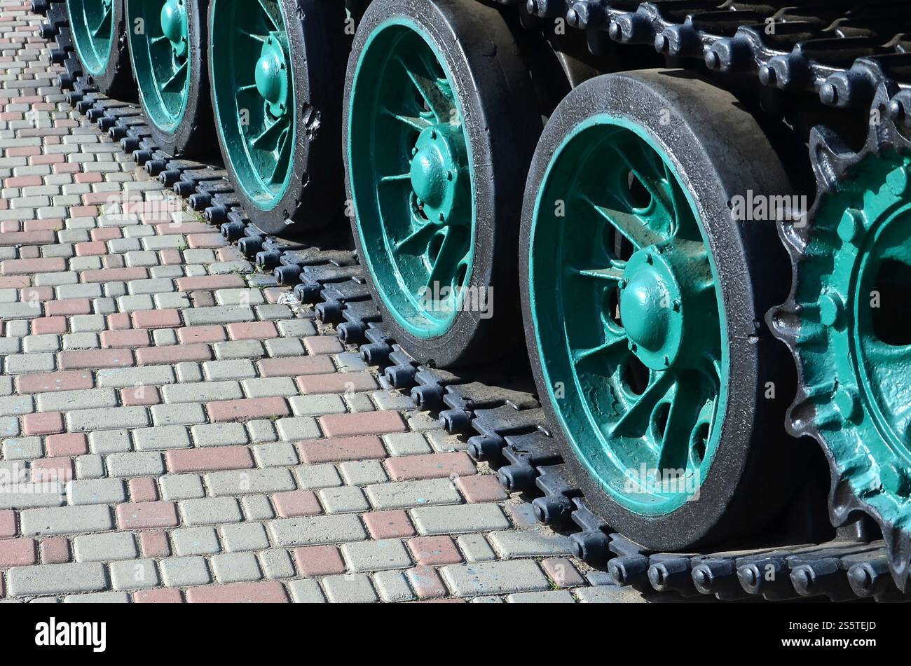Un véhicule militaire sur chenilles se tient sur un carré de pavés. Photo de chenilles vertes avec des roues en métal que les faire tourner Banque D'Images
