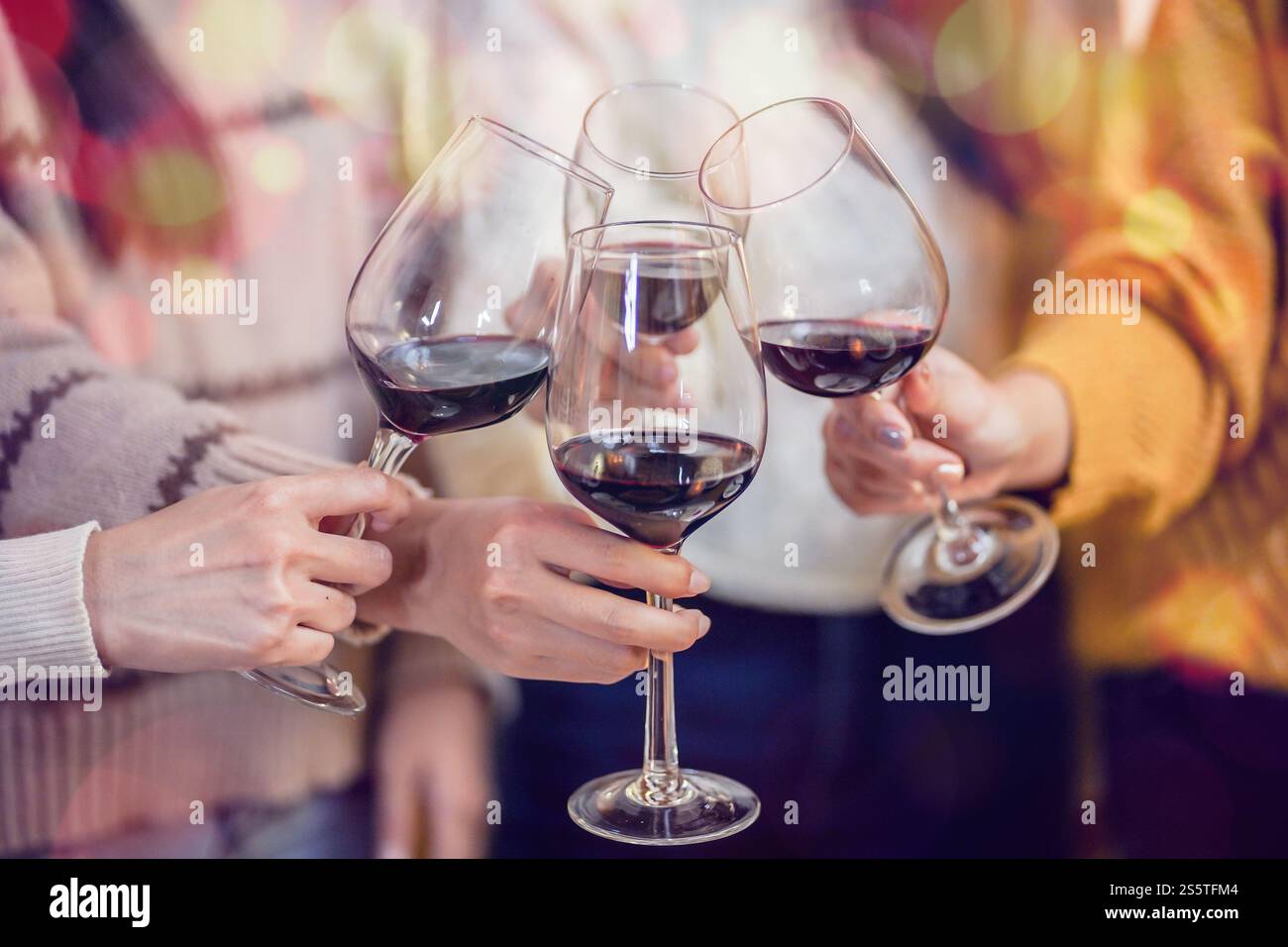 Amis joyeux appréciant la fête d'anniversaire à la maison. Amis asiatiques acclamant boire du vin rouge pour célébrer Noël ou la fête du nouvel an. Banque D'Images