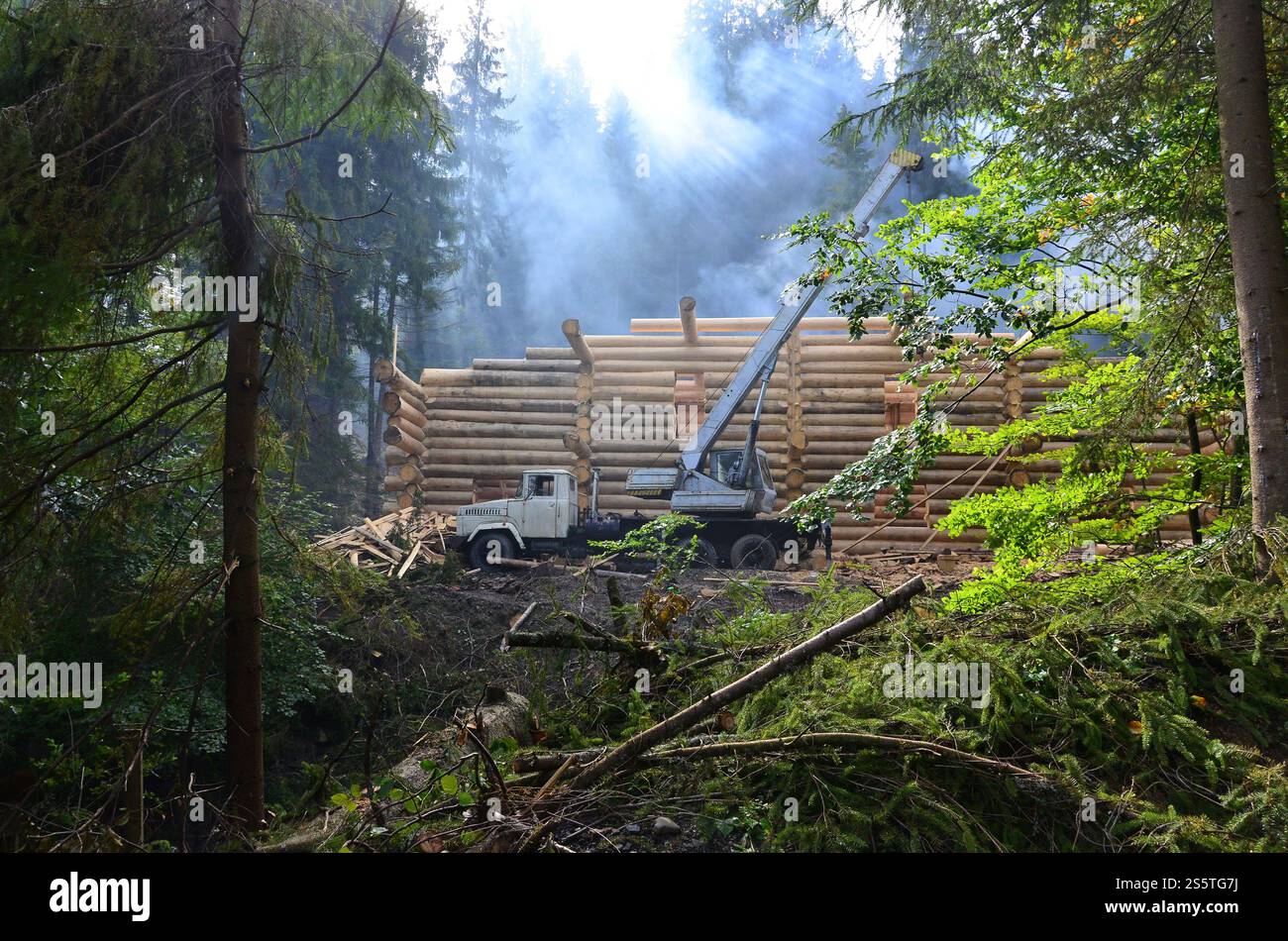 Le processus de construction d'une maison en bois à partir de poutres en bois de forme cylindrique. Grue en état de fonctionnement Banque D'Images