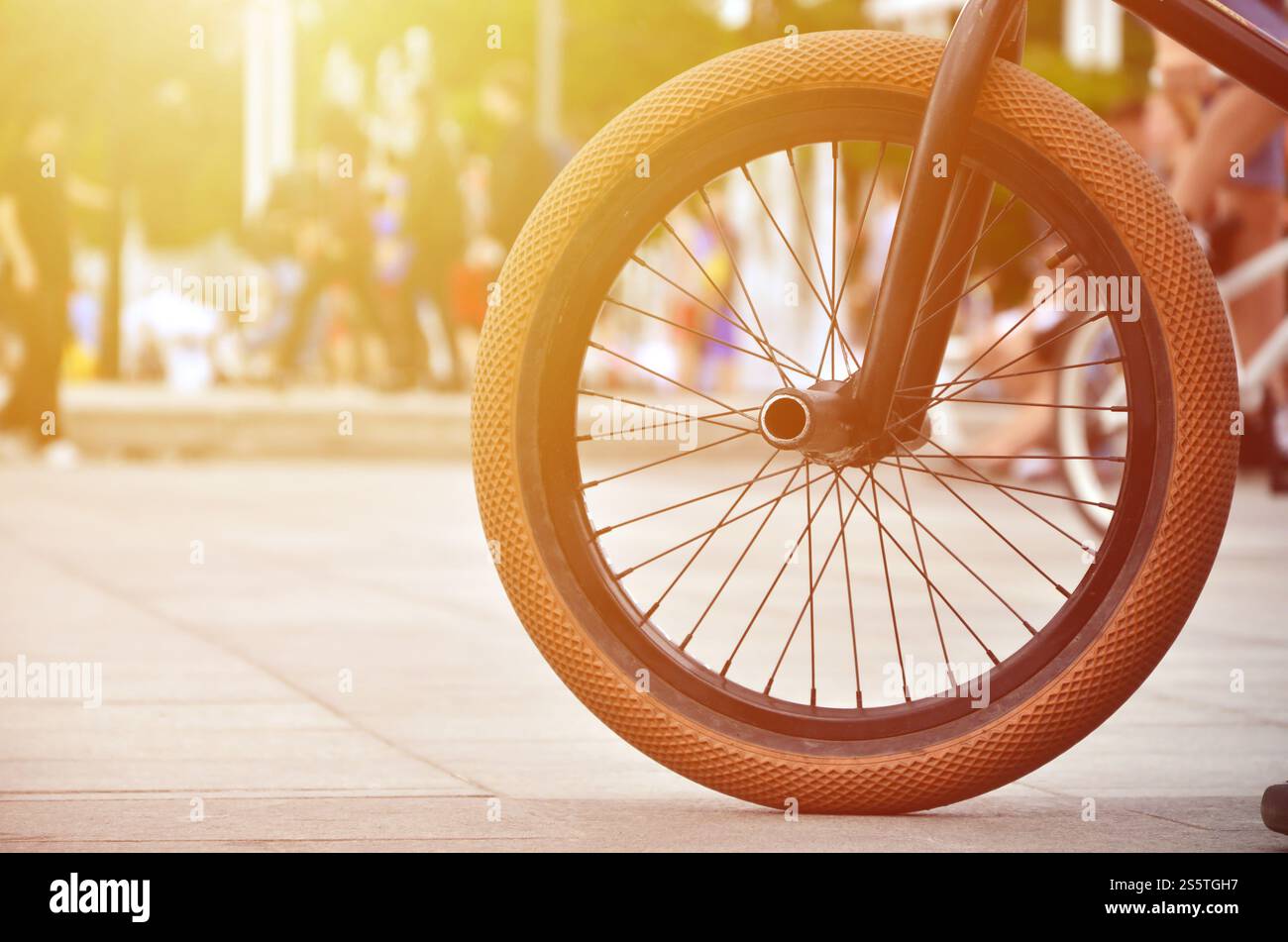 Une roue de vélo BMX dans le contexte d'une rue avec des coureurs cyclistes brouillée. Extreme Sports Concept Banque D'Images Une roue de vélo BMX dans le contexte d'une rue avec des coureurs cyclistes brouillée. Extreme Sports Concept Banque D'Images