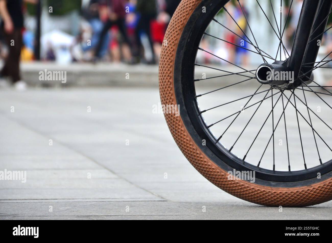 Une roue de vélo BMX dans le contexte d'une rue avec des coureurs cyclistes brouillée. Extreme Sports Concept Banque D'Images Une roue de vélo BMX dans le contexte d'une rue avec des coureurs cyclistes brouillée. Extreme Sports Concept Banque D'Images