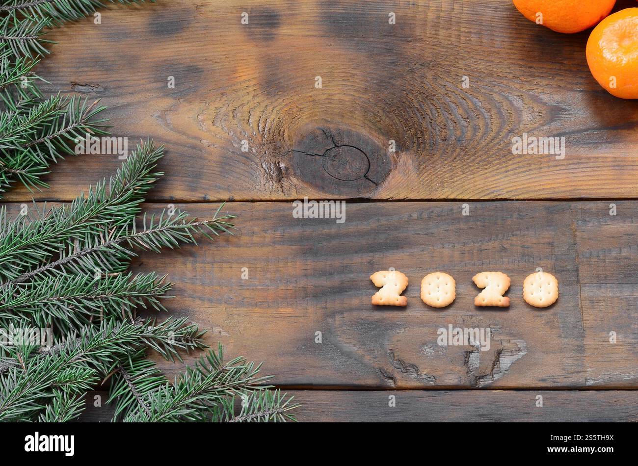 Carte de vacances de Noël avec mandarines, craquelin 2020 chiffres et branches de sapin avec espace de copie. Vue de dessus, pose à plat. Mandarines, craquelins 2020 chiffres et Banque D'Images