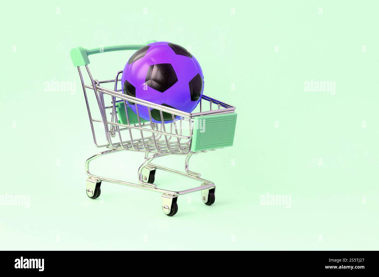 Ballon de football violet dans un panier sur turquoise. Le concept de vente d'équipements sportifs, les prévisions pour les matchs sportifs, les Paris sportifs. Vente Banque D'Images