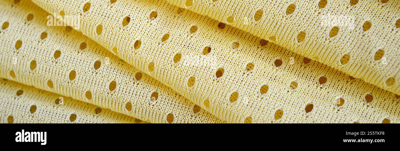 Fond de modèle textile de tissu de tissu de sport de maille jaune. Couleur jaune maillot de football vêtements tissu texture vêtements de sport. Poreux respirant Banque D'Images