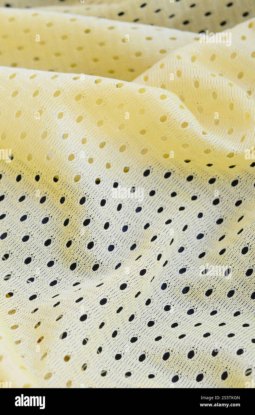 Fond de modèle textile de tissu de tissu de sport de maille jaune. Couleur jaune maillot de football vêtements tissu texture vêtements de sport. Poreux respirant Banque D'Images