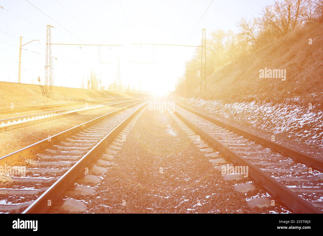 Paysage d'un chemin de fer d'hiver russe enneigé sous la lumière du soleil les rails et les traverses sous la neige de décembre. Chemins de fer russes en détail. Hiver Banque D'Images