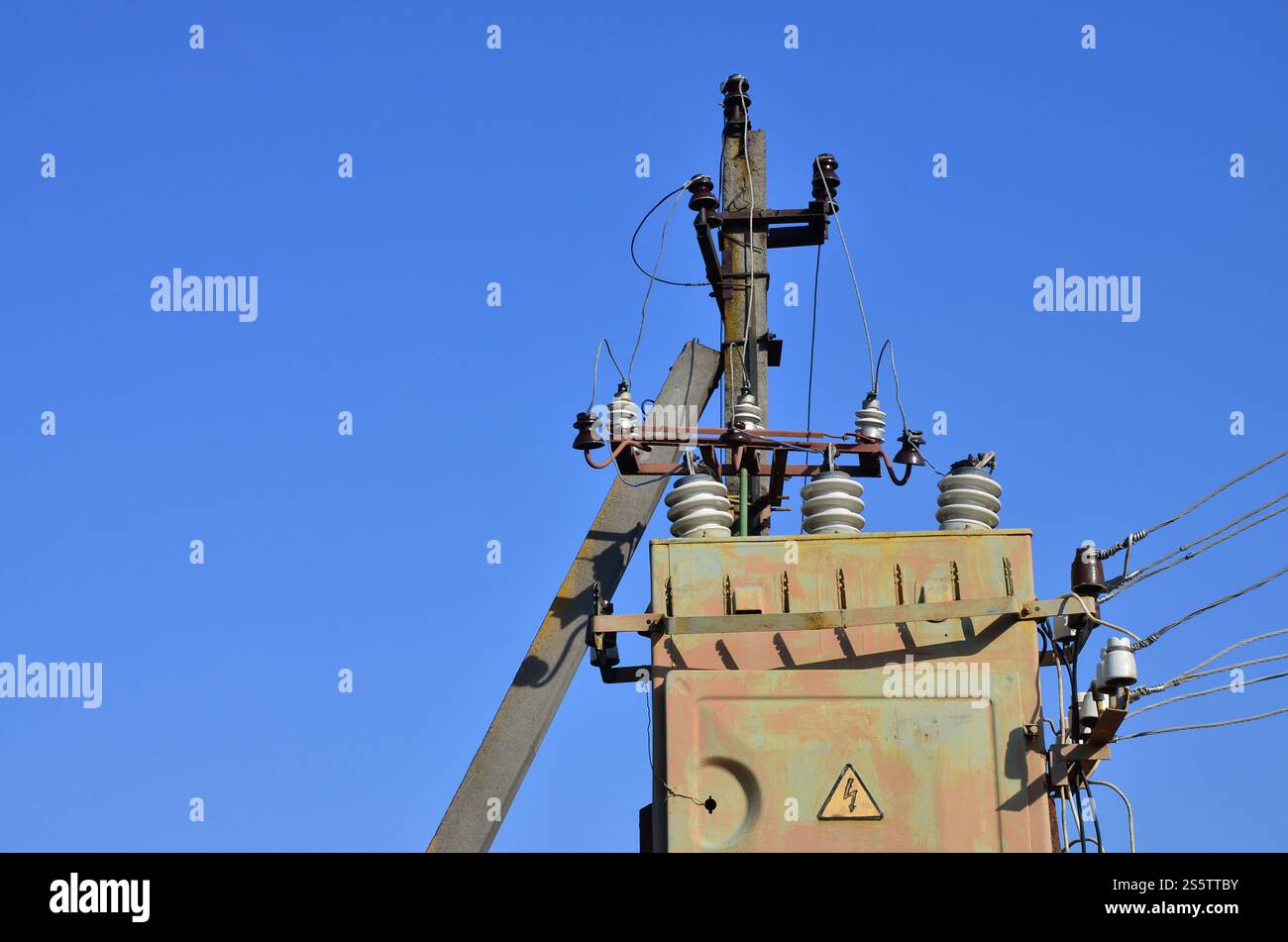 Vieux et obsolètes de transformateur électrique dans le contexte d'un ciel bleu. Dispositif pour la distribution de fourniture de l'énergie à haute tension Banque D'Images