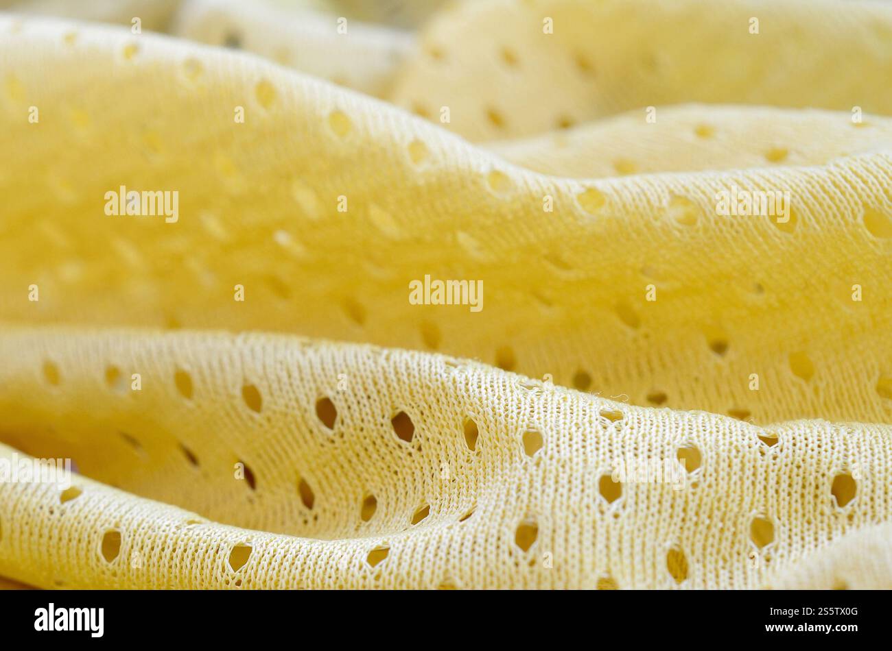 Fond de modèle textile de tissu de tissu de sport de maille jaune. Couleur jaune maillot de football vêtements tissu texture vêtements de sport. Poreux respirant Banque D'Images