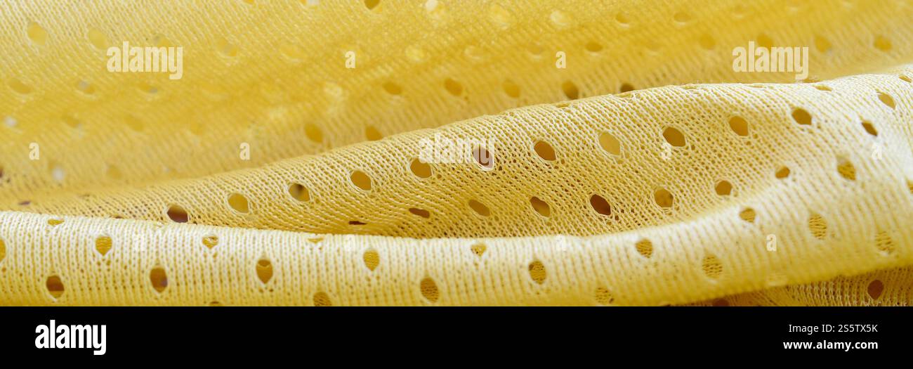 Fond de modèle textile de tissu de tissu de sport de maille jaune. Couleur jaune maillot de football vêtements tissu texture vêtements de sport. Poreux respirant Banque D'Images