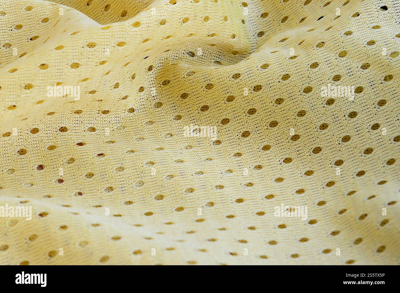 Fond de modèle textile de tissu de tissu de sport de maille jaune. Couleur jaune maillot de football vêtements tissu texture vêtements de sport. Poreux respirant Banque D'Images