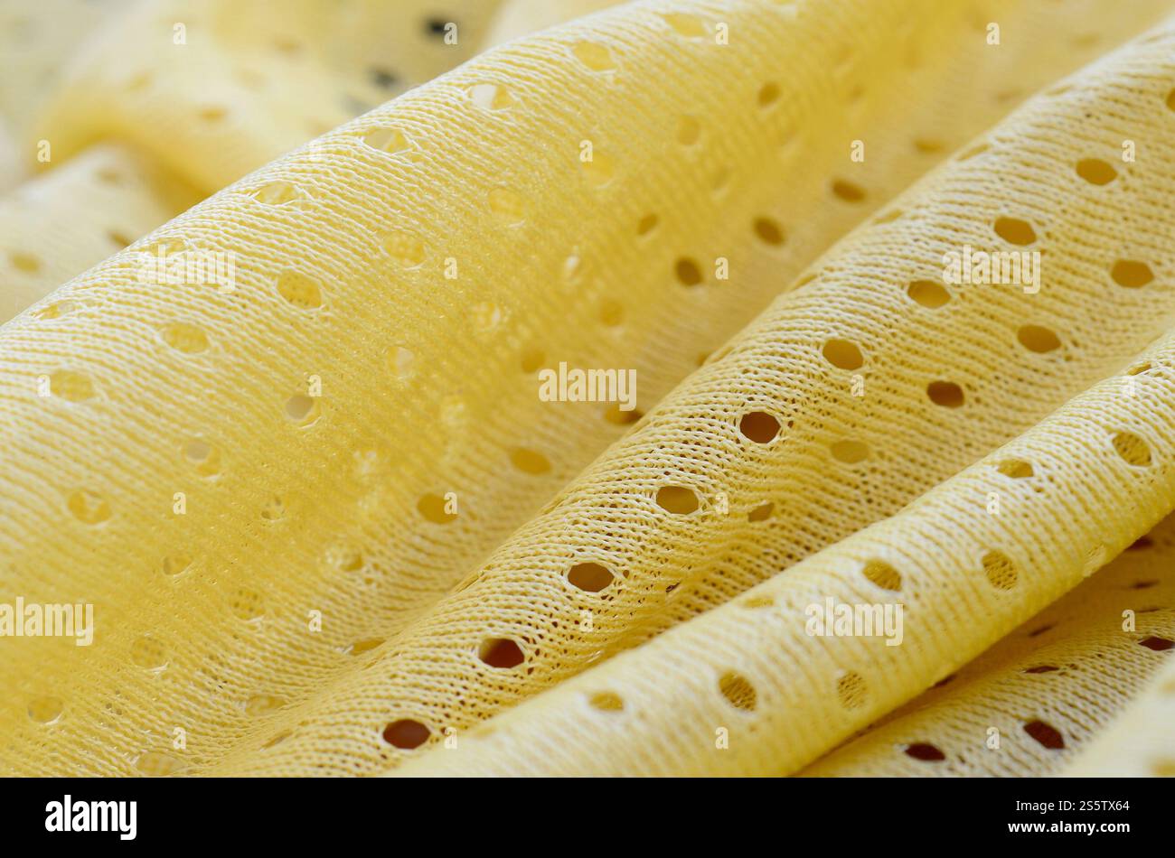 Fond de modèle textile de tissu de tissu de sport de maille jaune. Couleur jaune maillot de football vêtements tissu texture vêtements de sport. Poreux respirant Banque D'Images