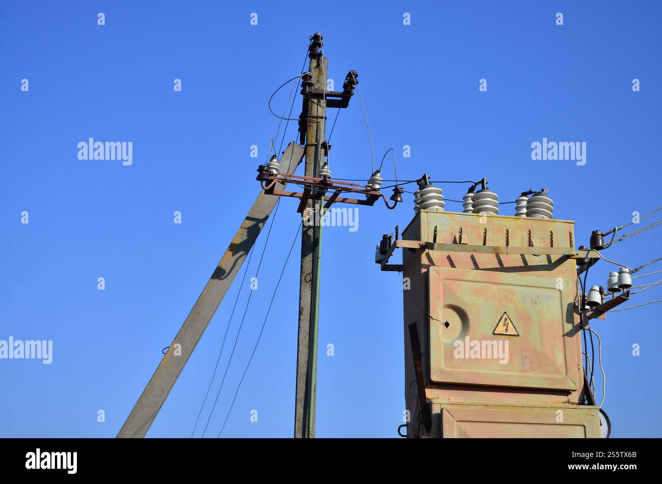 Vieux et obsolètes de transformateur électrique dans le contexte d'un ciel bleu. Dispositif pour la distribution de fourniture de l'énergie à haute tension Banque D'Images