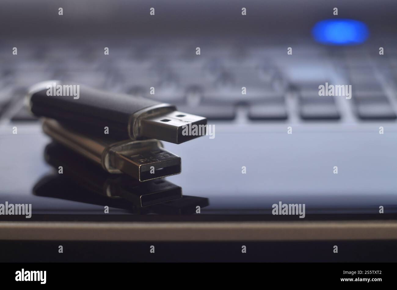 Cartes flash USB couchées sur le boîtier noir de l'ordinateur portable devant son clavier. Stockage de mémoire virtuelle avec sortie USB. Cartes mémoire sur le clavier de l'ordinateur portable Banque D'Images