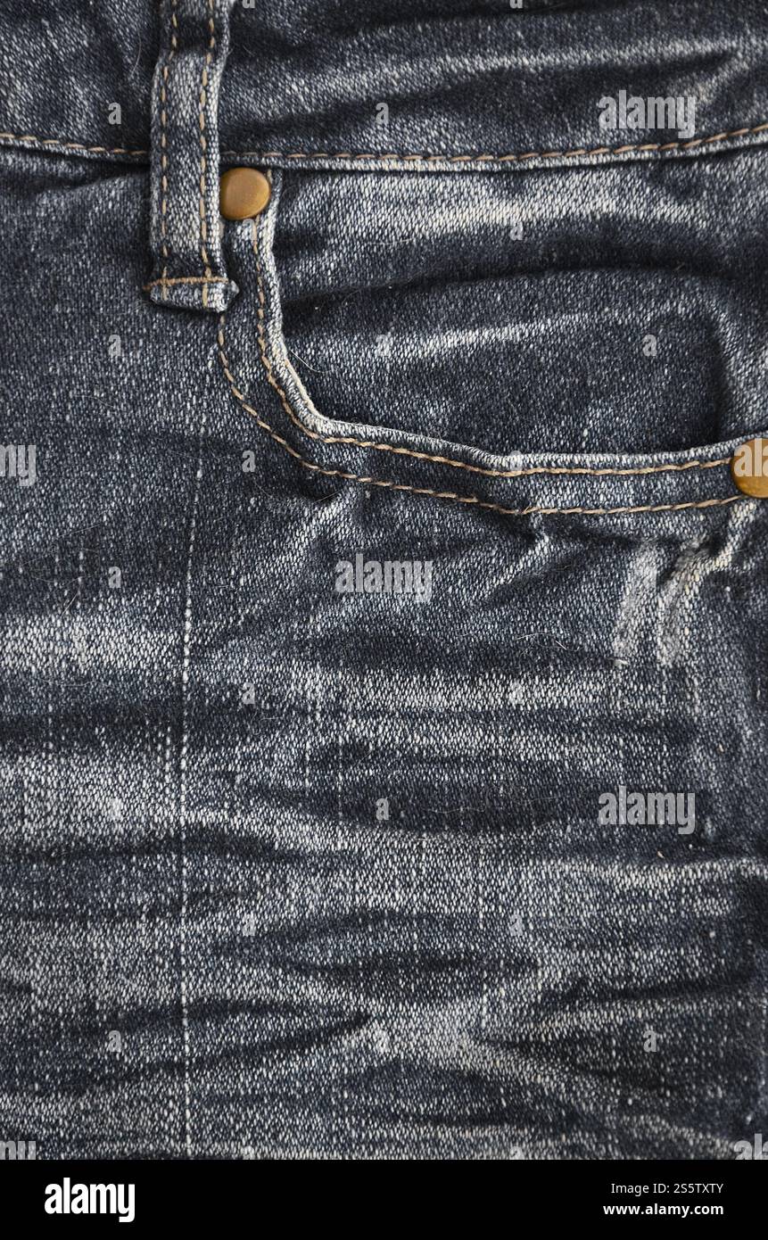 Fragment de texture denim en teintes classiques avec des coutures de tissu fin et une grande poche. L'image de fond sur la production de denim rigide Banque D'Images