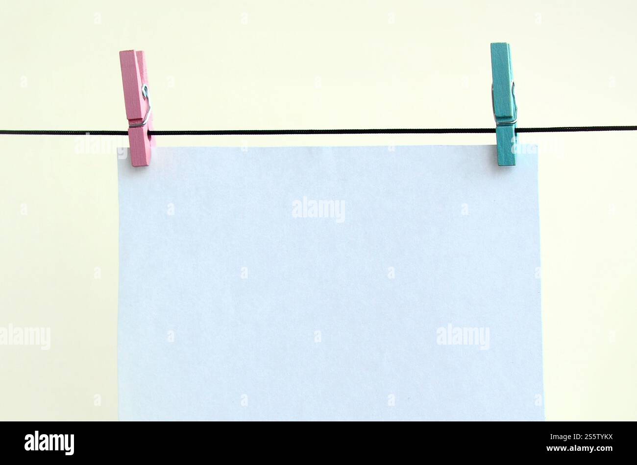 Cartes blanches vierges sur corde, fond de mur clair. Rappel créatif, petites feuilles de papier sur une vieille épinglette, arrière-plan de mémo Banque D'Images