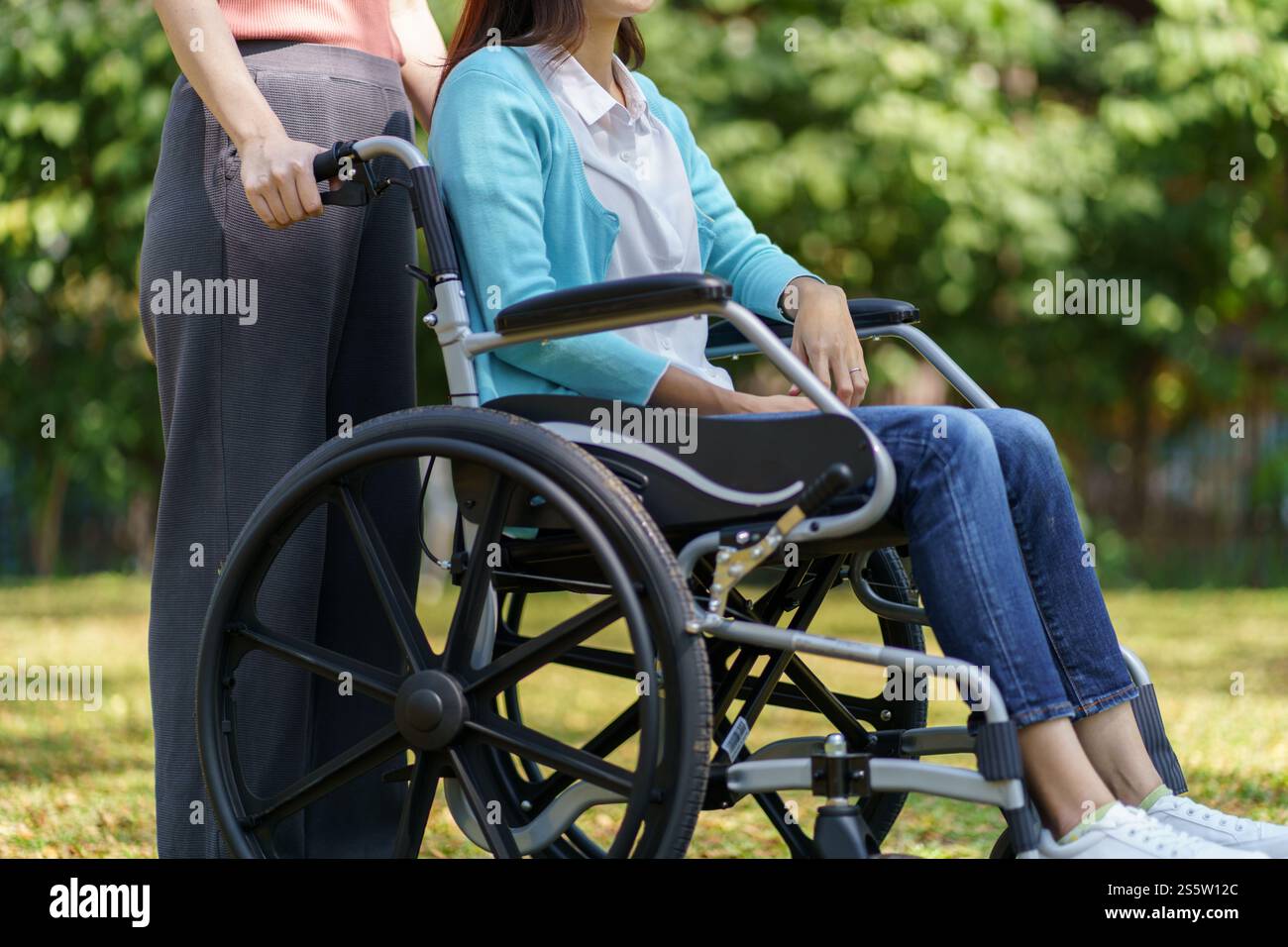 Femme asiatique triste dépressive en fauteuil roulant seul handicapé adulte. Banque D'Images