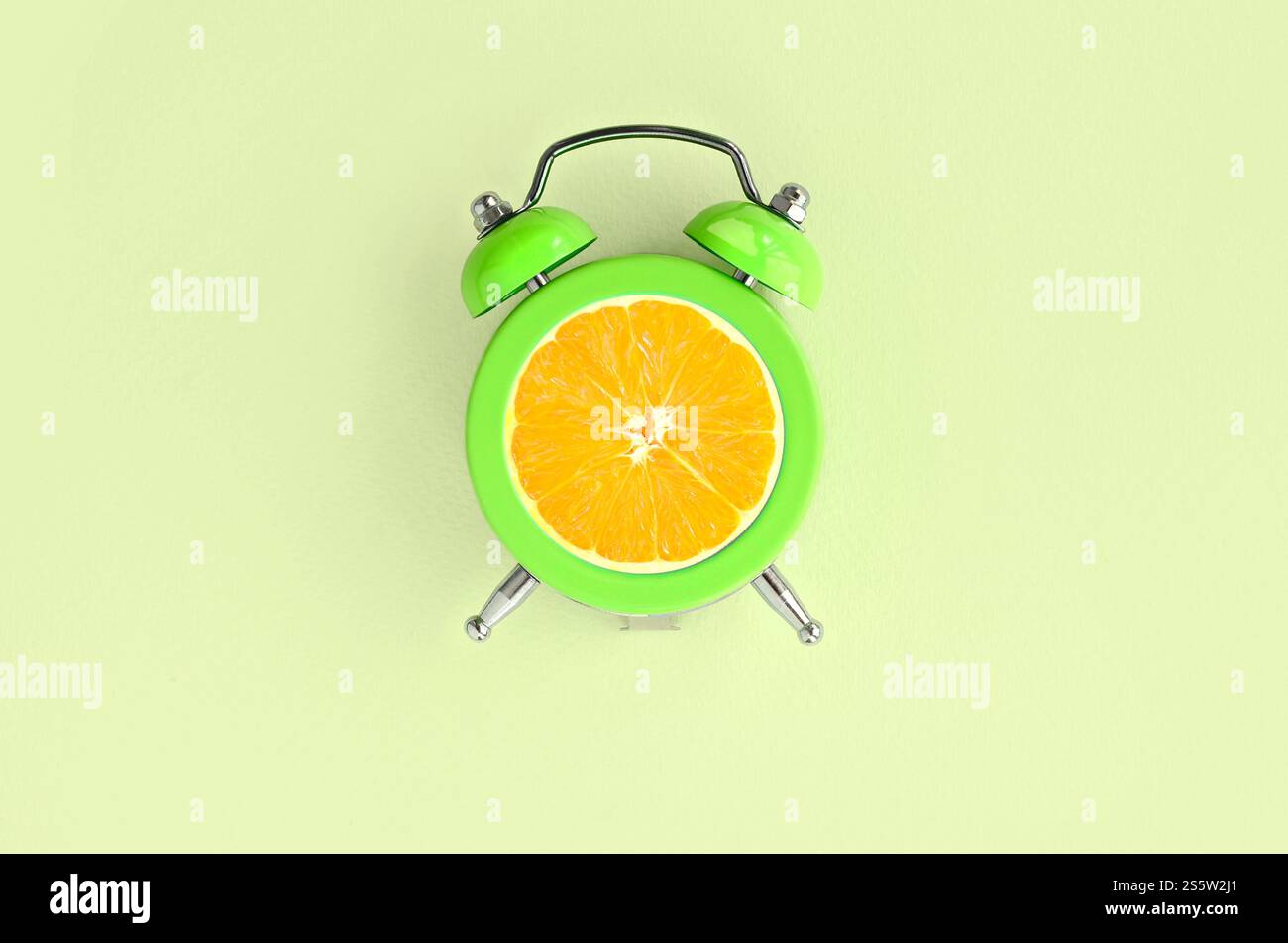 Réveil de tranche d'orange fraîche d'idée créative sur fond vert pastel. Concept commercial minimal. Idée de fruit créative pour produire du travail à l'intérieur Banque D'Images