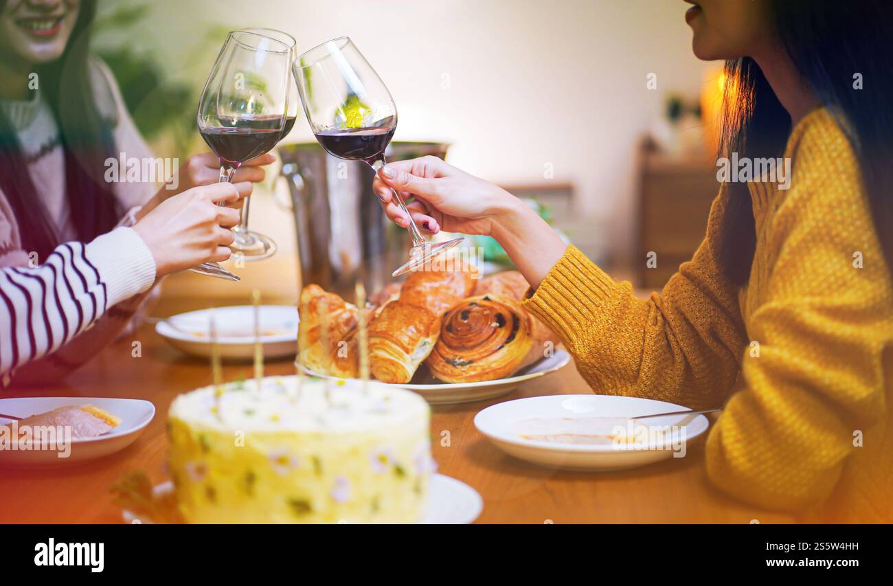 Amis joyeux appréciant la fête de vacances d'anniversaire à la maison. Amis asiatiques acclamant boire du vin rouge célébrant la fête du nouvel an Banque D'Images