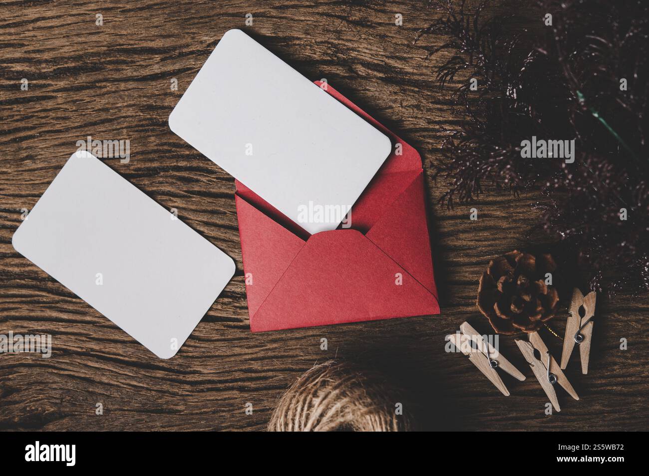 Deux cartes vierges avec enveloppe rouge et Clothespin est placé sur le bois. Banque D'Images