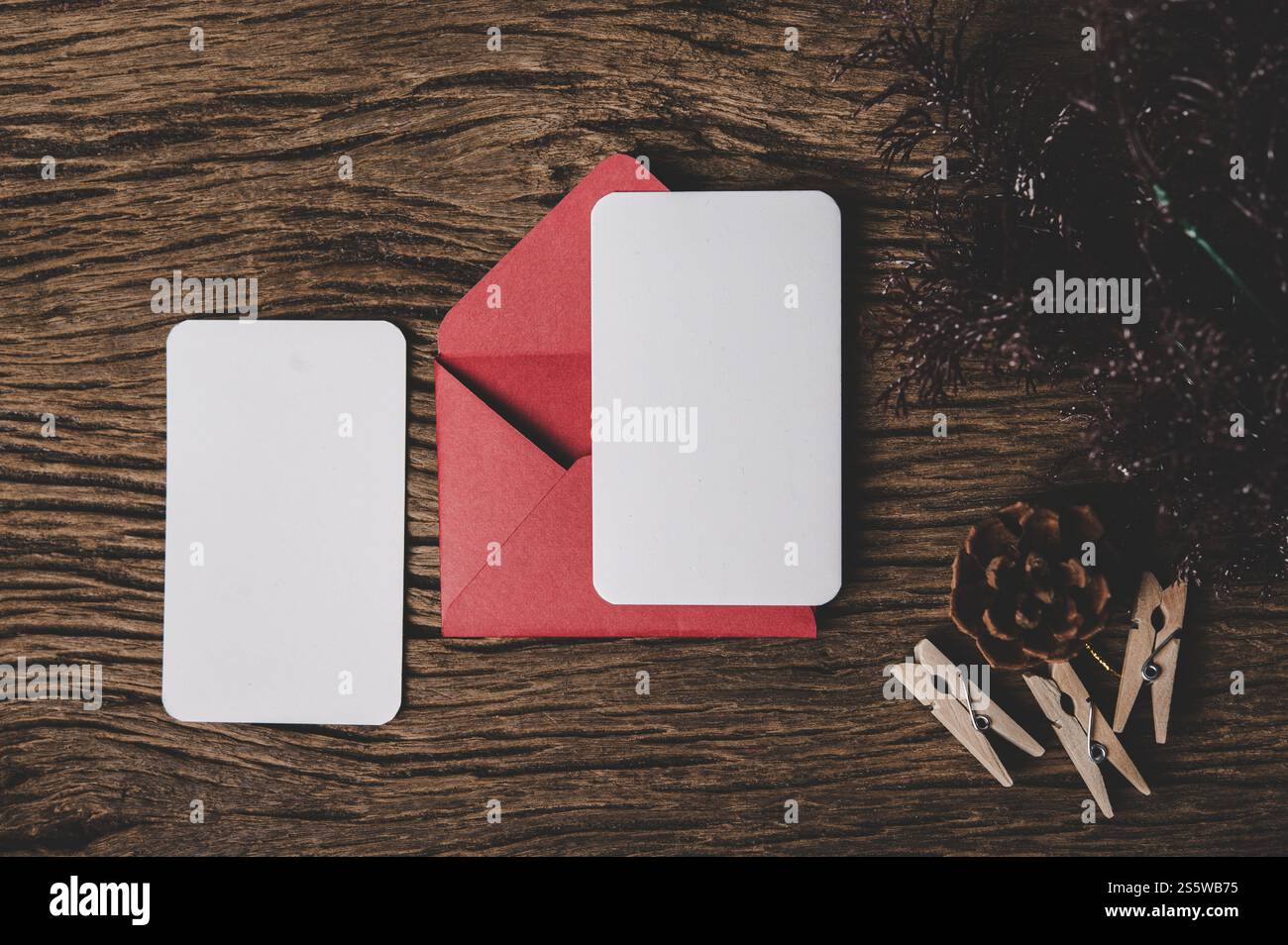 Deux cartes vierges avec enveloppe rouge et Clothespin est placé sur le bois. Banque D'Images