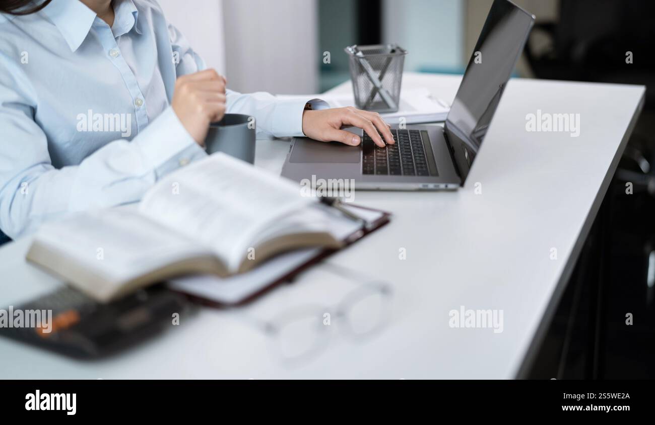 Femme travaillant à l'aide d'un ordinateur portable mains tapant sur le clavier. Travailler au bureau investisseur professionnel travaillant nouveau projet de démarrage Banque D'Images