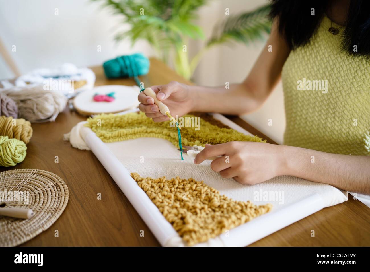 Aiguille perforée. Femme asiatique faisant tricoter Hobby à la main dans l'atelier de studio. Designer Workplace projet artisanal fait à la main concept de broderie DIY Banque D'Images
