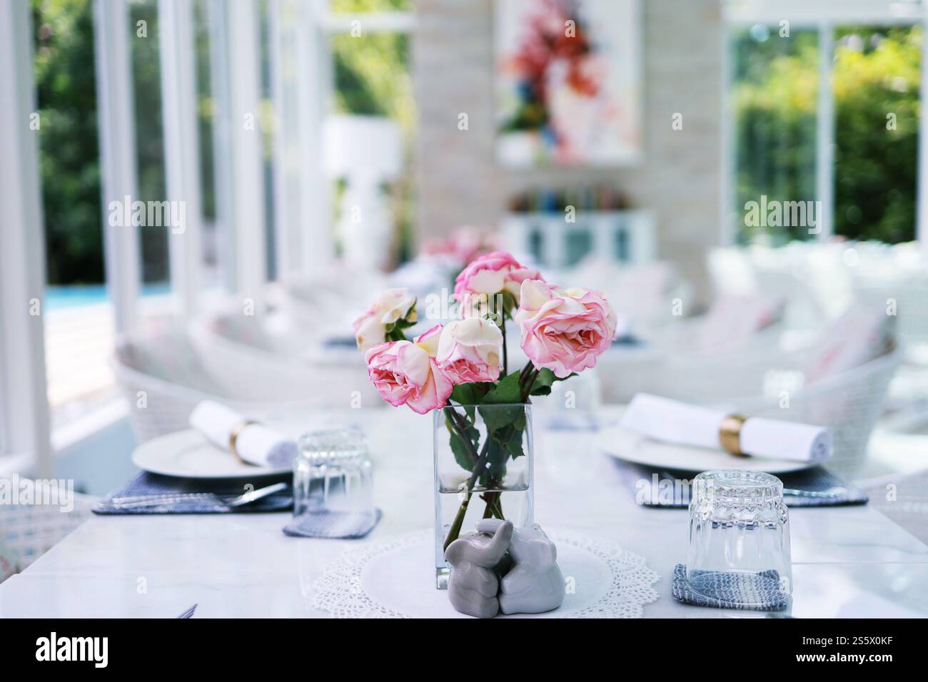 Fleur de roses roses naturelles dans le vase se tient sur la table dans un café pour l'arrière-plan. Banque D'Images