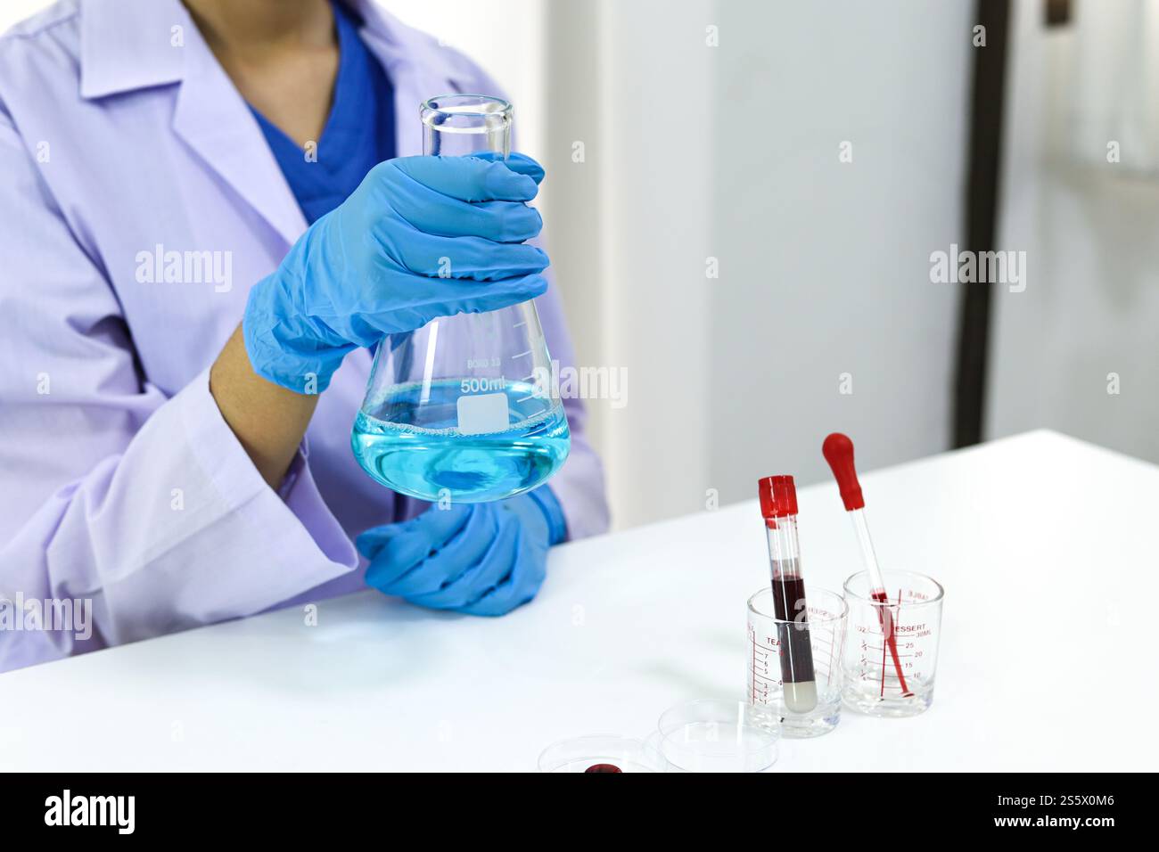 Scientifique tenant un tube de prélèvement sanguin infecté par le coronavirus covid-19. Analyse ADN du sang en laboratoire avec des tubes de prélèvement de sang et Banque D'Images