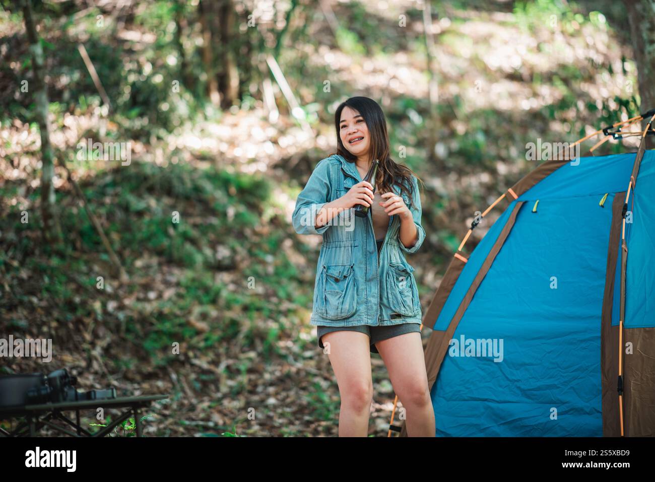 Jeunes belles femmes asiatiques et amis voyageurs se relaxant devant la tente de camping, ils aiment parler et boire de la bière avec plaisir et heureux Banque D'Images