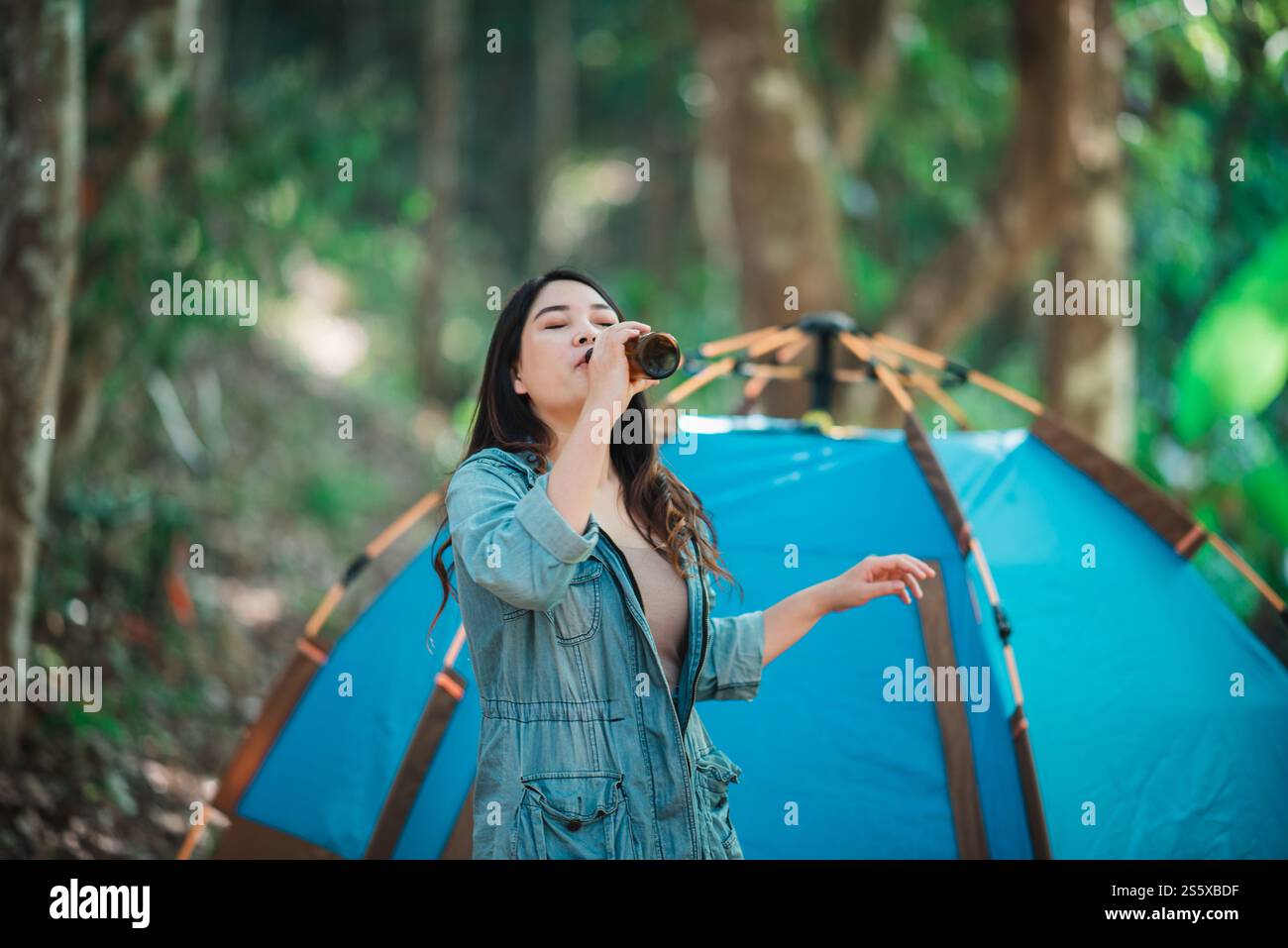 Jeunes belles femmes asiatiques et amis voyageurs se relaxant devant la tente de camping, ils aiment parler et boire de la bière avec plaisir et heureux Banque D'Images
