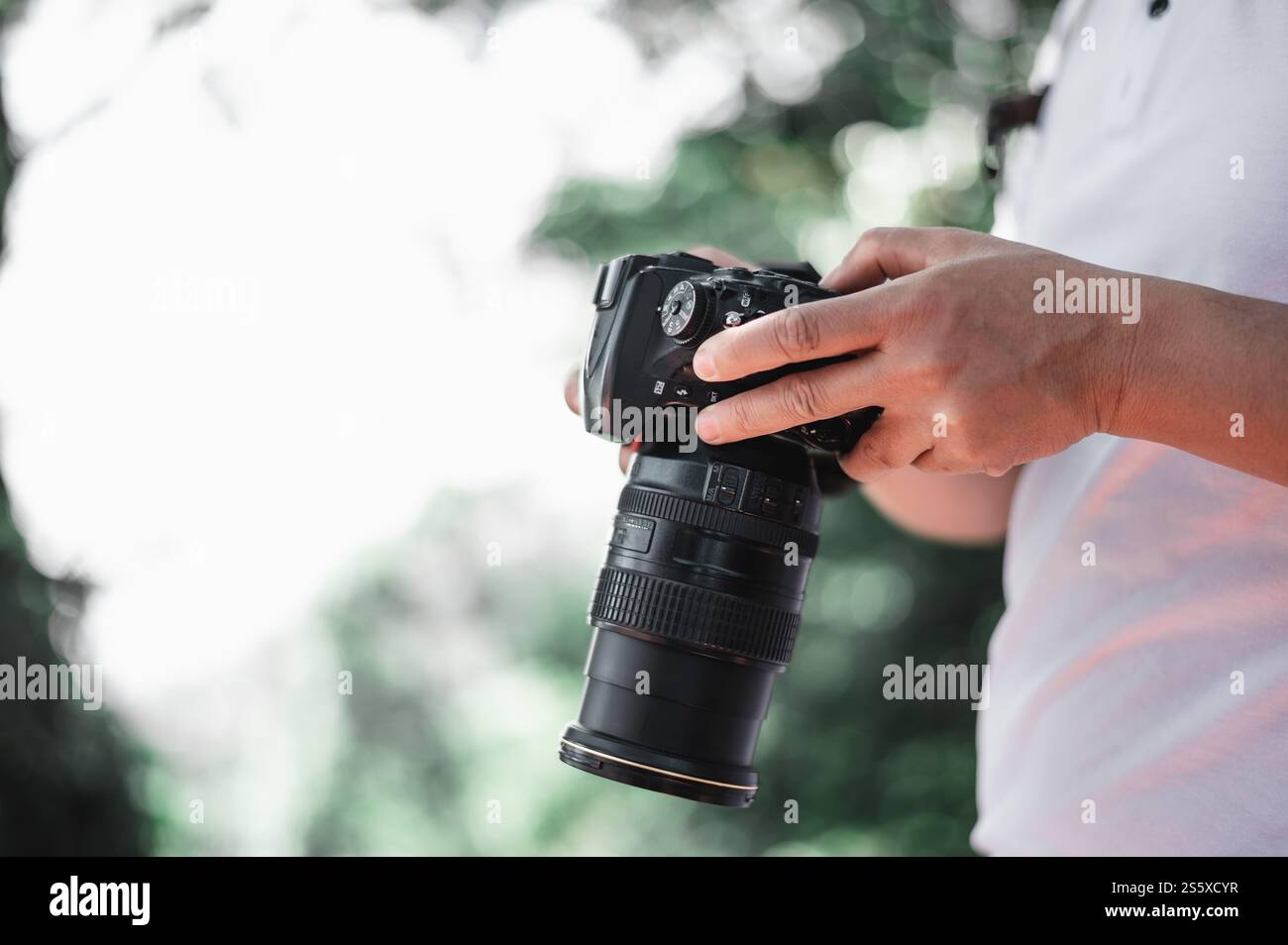 Gros plan de la main de l'homme vérifiant une image sur la caméra au parc avec espace de copie. Photographe de voyage. Vocation et concept de vacances. Banque D'Images