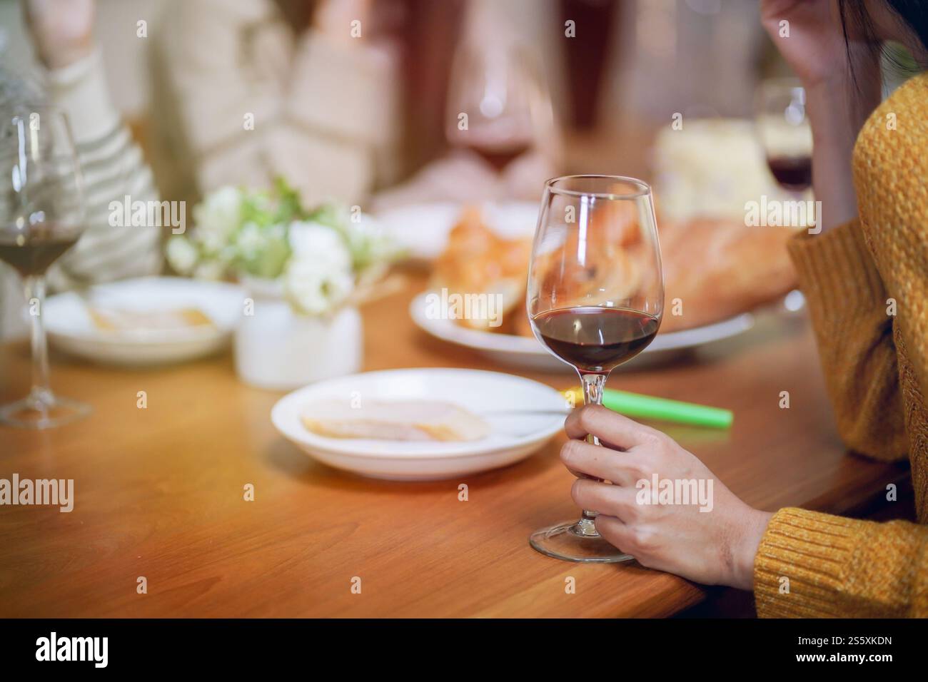 Amis joyeux appréciant la fête de vacances d'anniversaire à la maison. Amis asiatiques acclamant boire du vin rouge célébrant la fête du nouvel an Banque D'Images