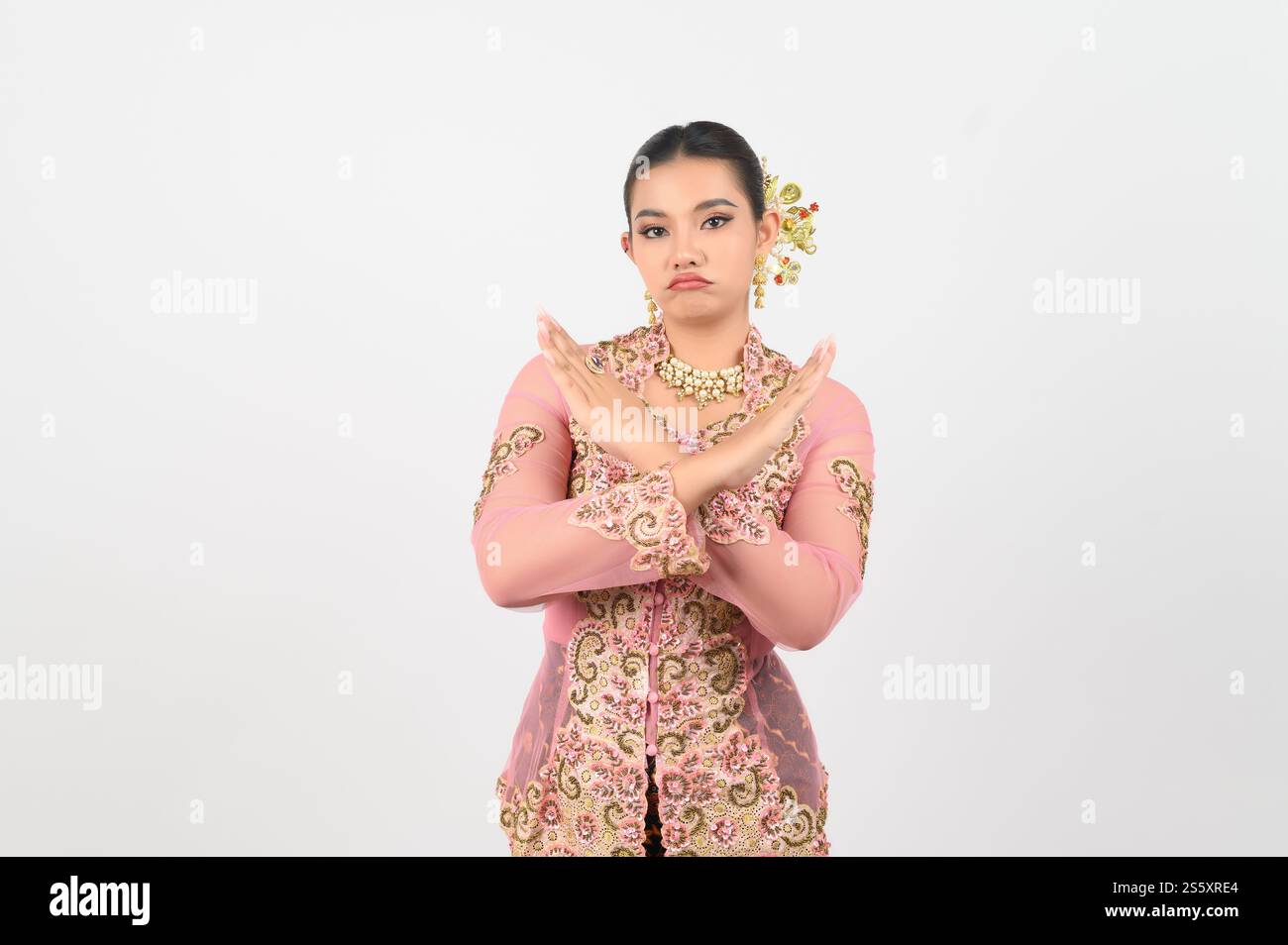 Jeune belle femme habille dans la culture locale dans la région du sud avec se sentir mal et refusé sur la pose croiser ses mains avec se sentir bouleversé et grimace sur Banque D'Images