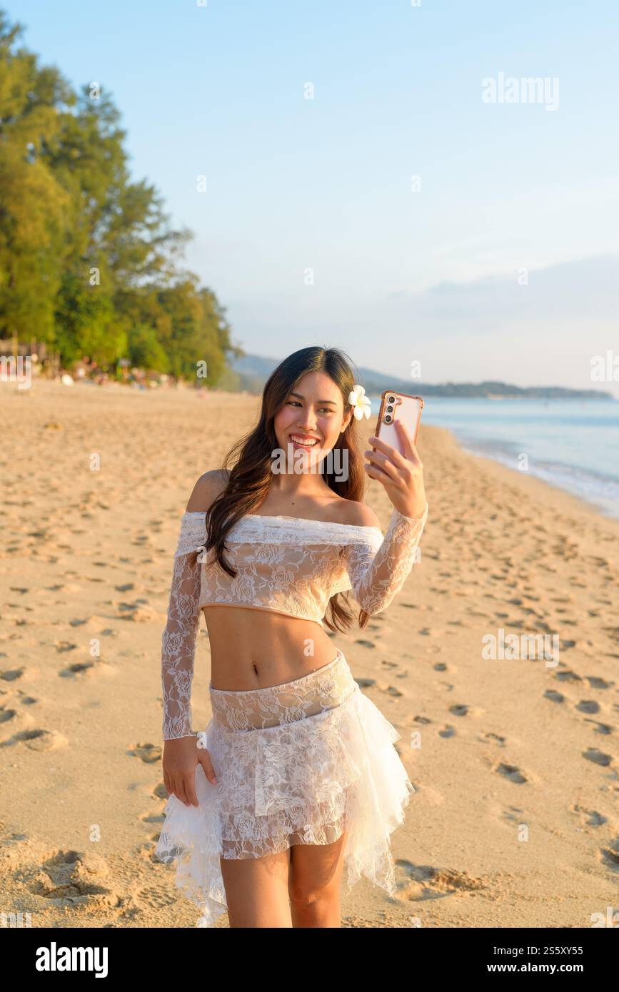 Heureuse jeune femme prenant Selfie avec le concept de fond vibrant Ocean Sunset Banque D'Images