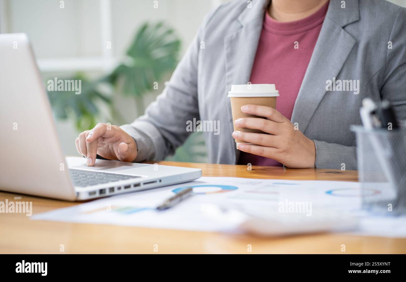 Femme d'affaires comptable analysant les graphiques d'investissement facture et appuyant sur les boutons de calculatrice sur les documents. Commis comptable Conseiller de banque Banque D'Images