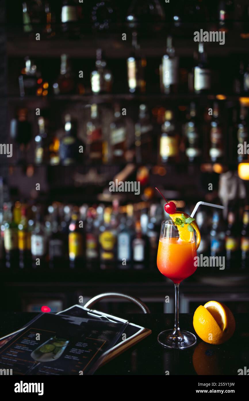 Cocktail boisson alcoolisée avec comptoir de bar classique avec des bouteilles en arrière-plan de bar intérieur de liqueur floue Banque D'Images