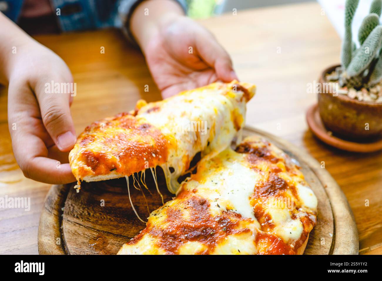 Une tranche de fromage mozzarella pizza végétarienne fraîche chaude très fromagère. Fromage fondant italien Pizza Margherita à la main Banque D'Images