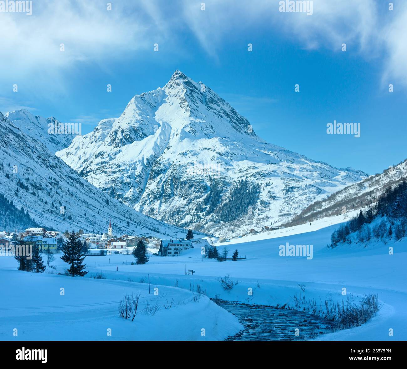 Vue sur les cours d'eau de montagne en hiver et village dans la vallée (Autriche). Banque D'Images